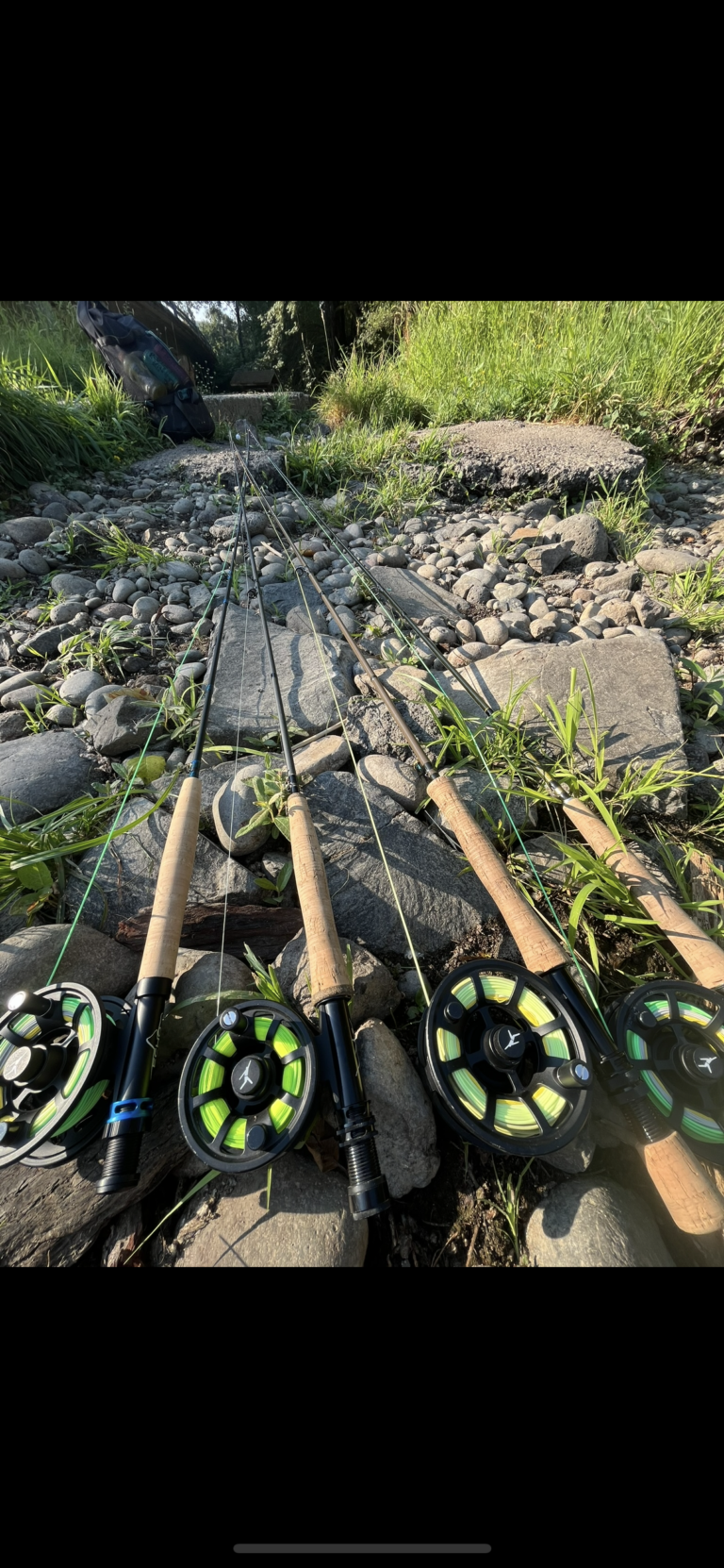 Fly rods and reels prepared for Oregon fly fishing along scenic riverbank