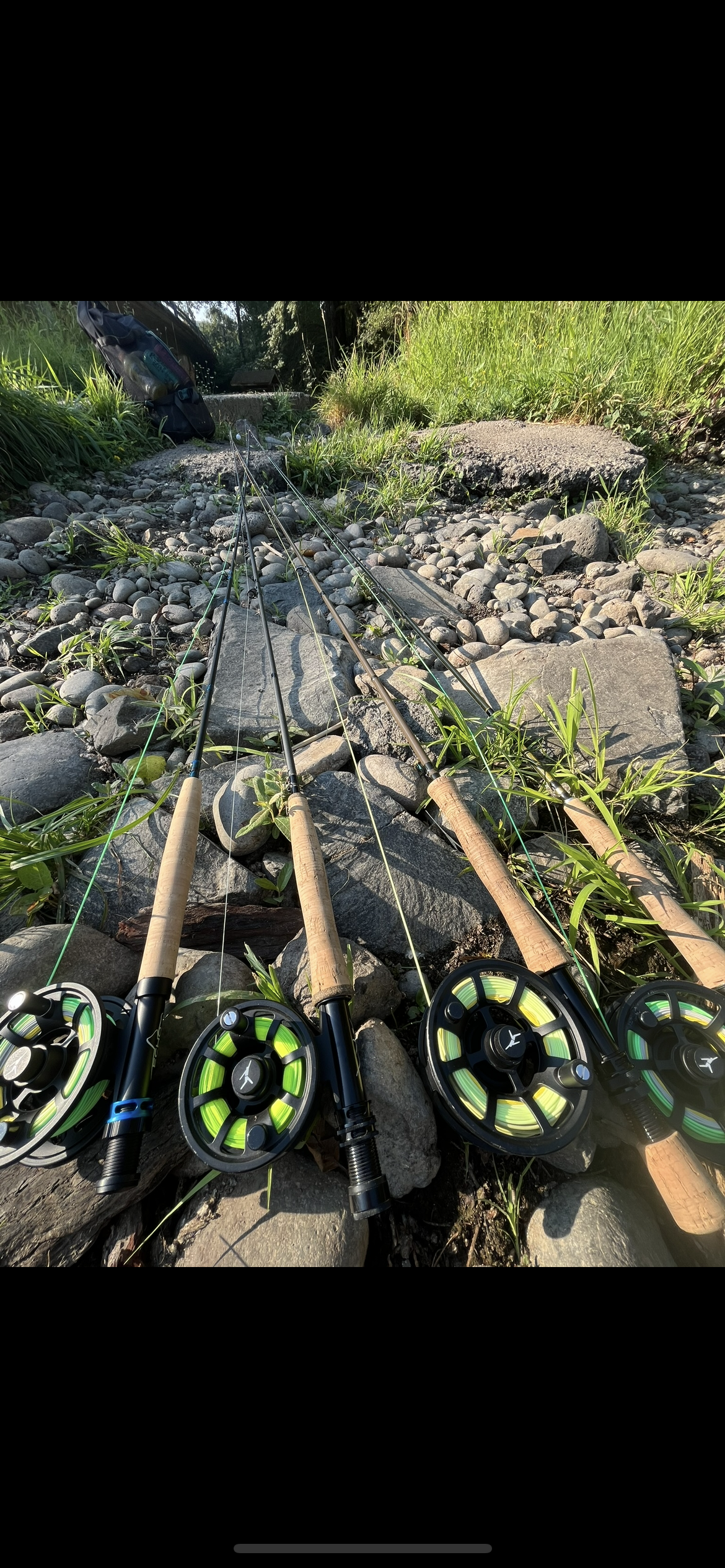 Fly rods and reels prepared for Oregon fly fishing along scenic riverbank