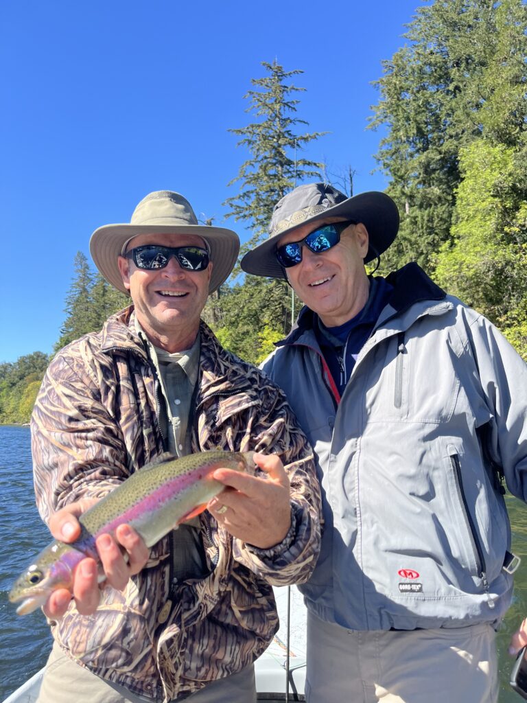 Two anglers holding rainbow trout during Oregon fly fishing