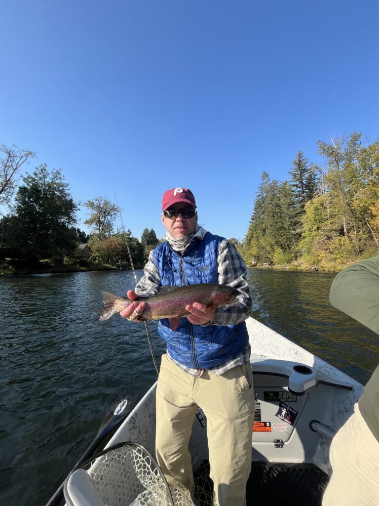 Angler holding trout during Oregon fly fishing in mountain river